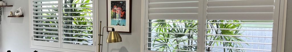 Widescreen view of living area and opened plantation shutters