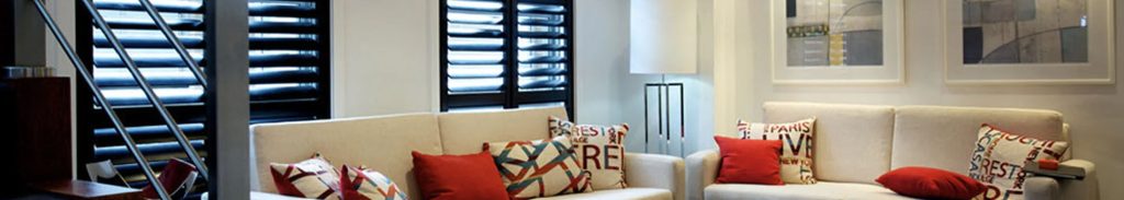 Widescreen living area with black plantation shutters in background