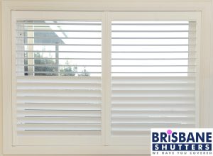 Close up of white plantation shutters half open