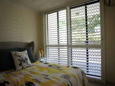 Opened plantation shutters in bedroom