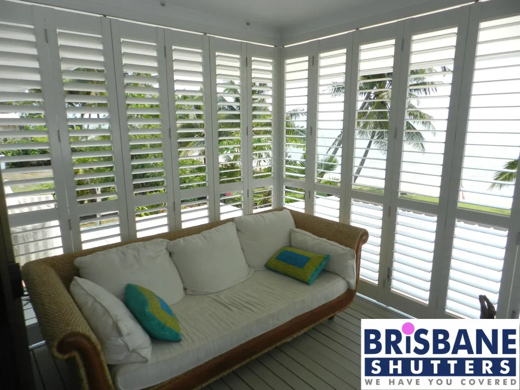 Couch in front of external plantation shutters on patio