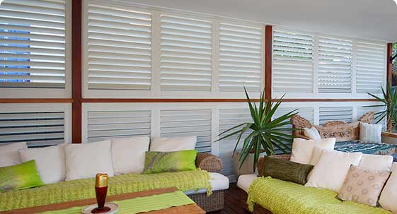 Outdoor lounge area with white shutters on wall