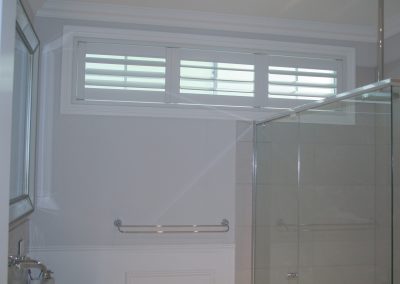 close up of low profile plantation shutters in bathroom