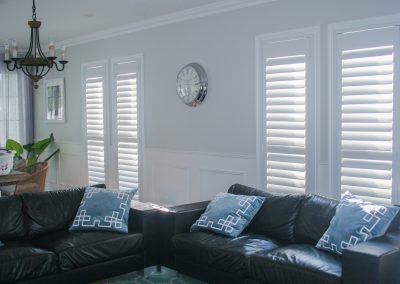 lounge room shot, black leather couches and plantation shutters