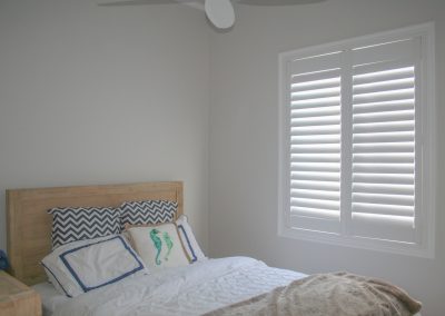 white plantation shutters in guest bedroom