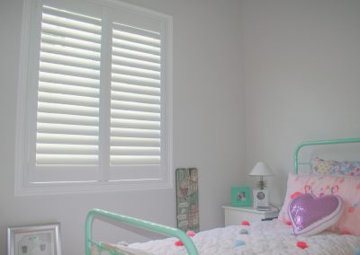 White plantation shutters in kids bedroom
