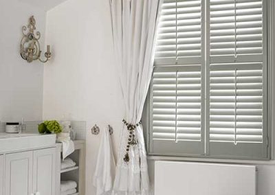 Green plantation shutters in laundry